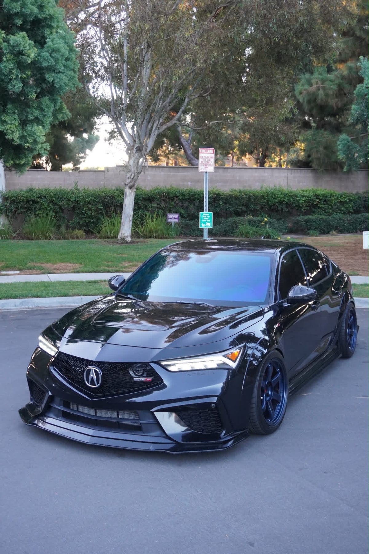 Front three-quarter view of a black Acura Integra Type S DE5 with gloss carbon fiber side mirror caps installed.