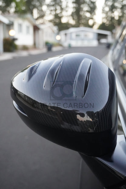 Front close-up showing the sculpted shape and gloss carbon fiber finish of an Acura Integra Type S DE5 mirror cap.