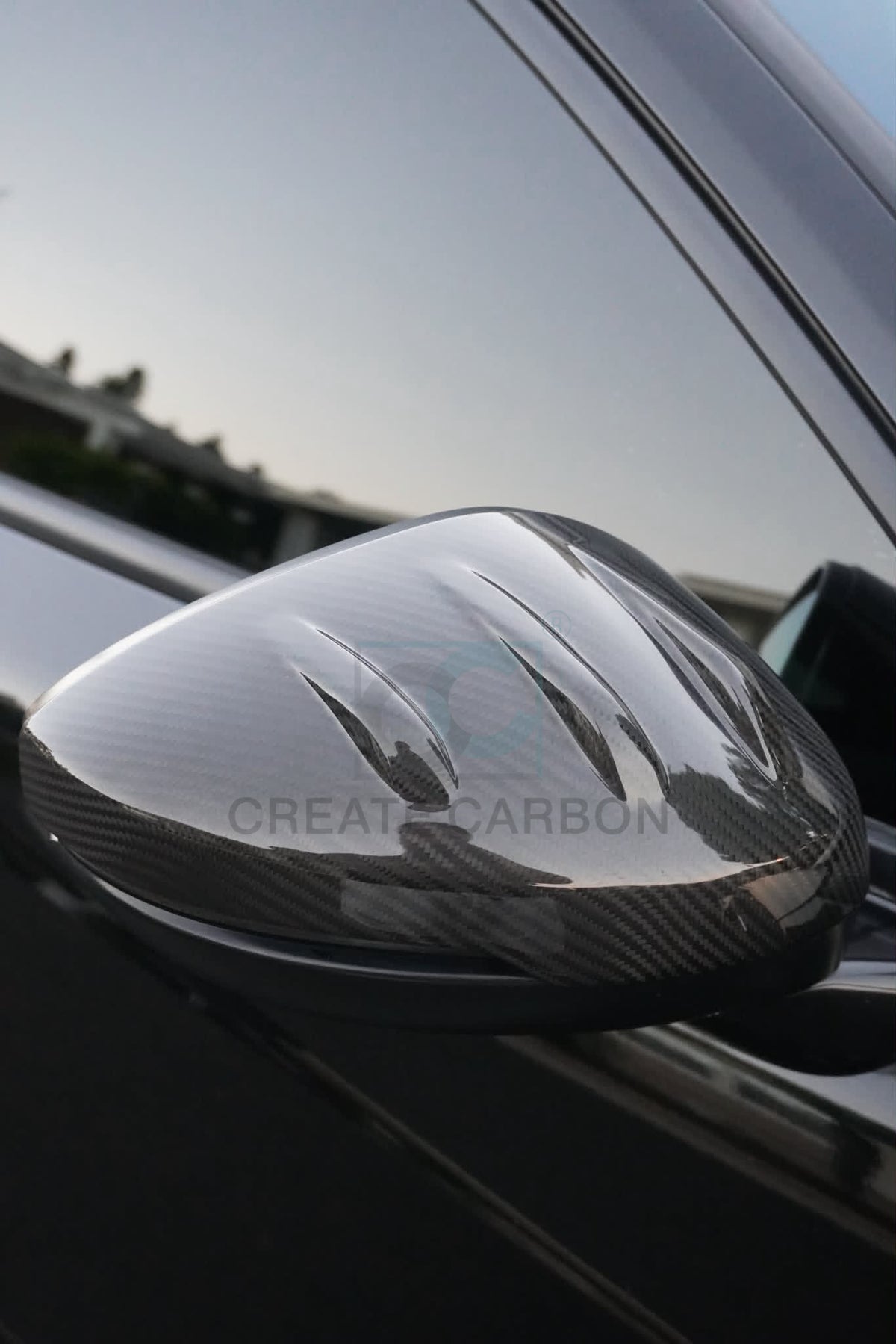 Angled view of a gloss carbon fiber side mirror cap installed on an Acura Integra Type S DE5.