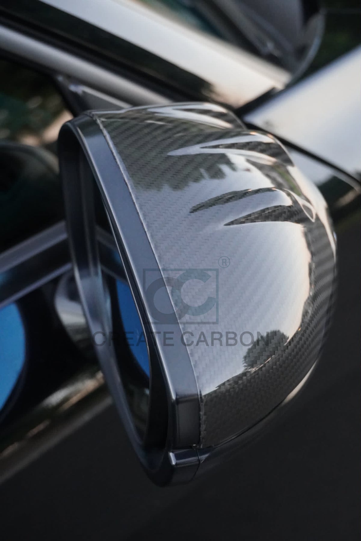 Close-up of the gloss carbon fiber side mirror cap and top edge on an Acura Integra Type S DE5.